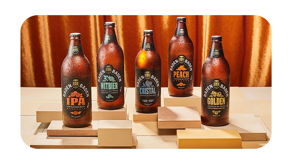 Imagem de garrafas de cerveja Baden Baden, incluindo variedades IPA, Witbier, Cristal, Peach e Golden, destacando a diversidade de sabores.