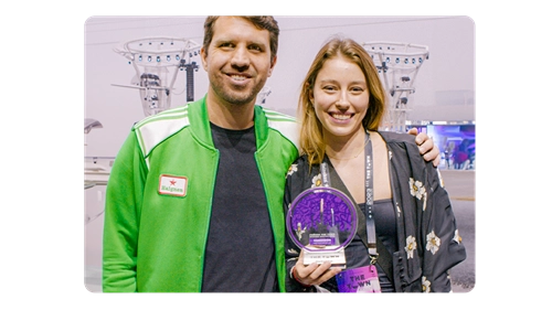 Premiação de destaque no evento, com vencedores sorridentes exibindo troféu. Exibição de conquistas e reconhecimento na indústria.